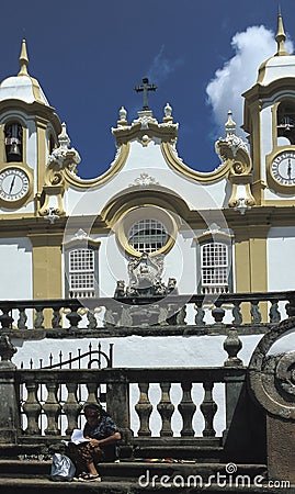 A woman relaxing outside the Igreja Matriz de Santo Antonio in T Editorial Stock Photo